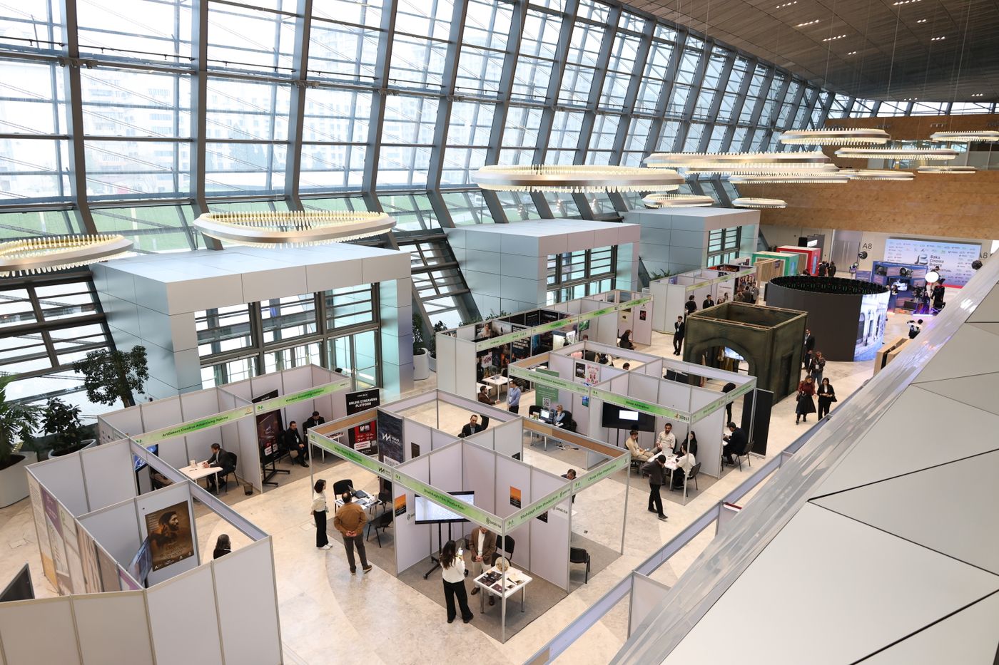 A bright exhibition hall arranged with booths for visitors