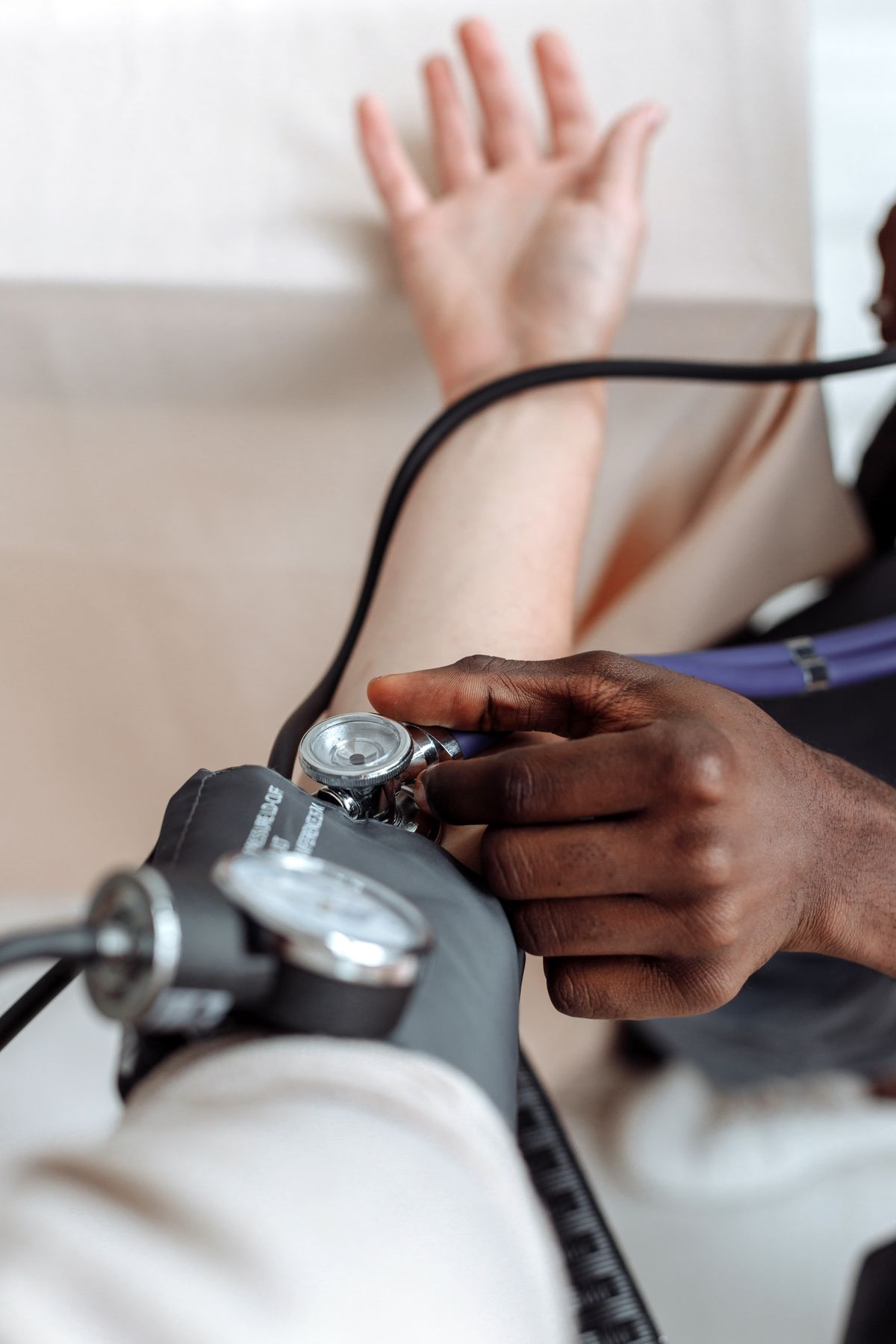 A healthcare professional checking a visitor's blood pressure